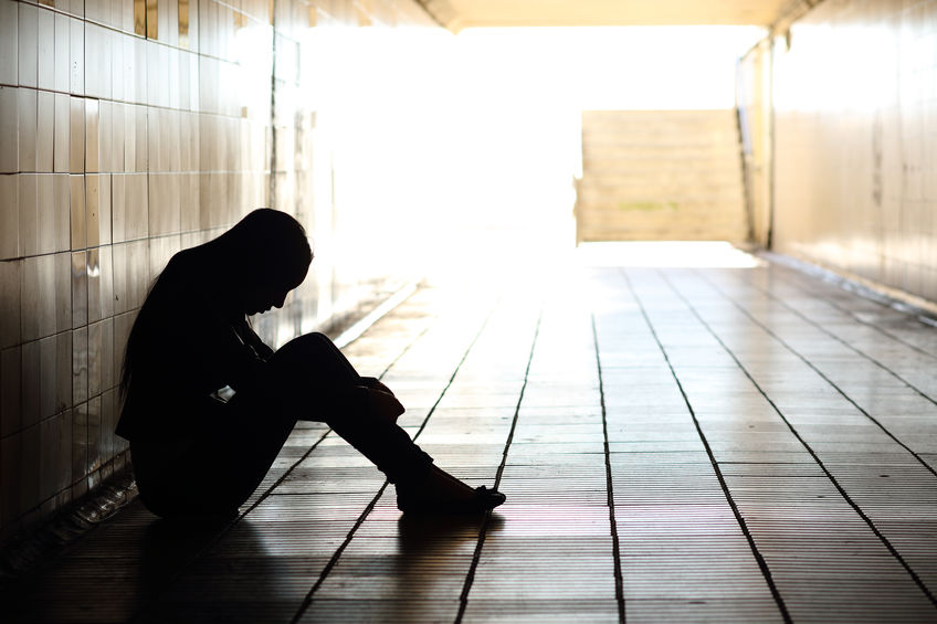 Photo of a teenager sitting inside a tunnel